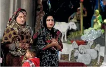  ??  ?? Pakistani Christian women pray during a Christmas mass at Sacred Heart Cathedral in Lahore.