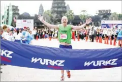 ?? SRENG MENG SRUN ?? Neil Burns crosses the finishing line to win the fourth Angkor Empire Internatio­nal Marathon on August 6, 2017.