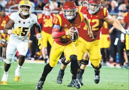  ?? Luis Sinco Los Angeles Times ?? CALEB WILLIAMS scrambles for a first down against Arizona State in the third quarter at the Coliseum. Williams frequently was forced to flee the pocket, rushing for 44 yards and a score while throwing for 348 yards and three touchdowns in lifting USC to 5-0.