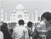  ?? MONEY SHARMA/GETTY-AFP ?? A tourist wears a face mask to protect against air pollution at the Taj Mahal in Agra, about 130 miles from New Delhi.