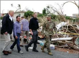  ?? The Associated Press ?? SURVEYING SCENE: President Donald Trump takes a walking tour to survey hurricane damage and recovery efforts Tuesday in a neighborho­od in Guaynabo, Puerto Rico.