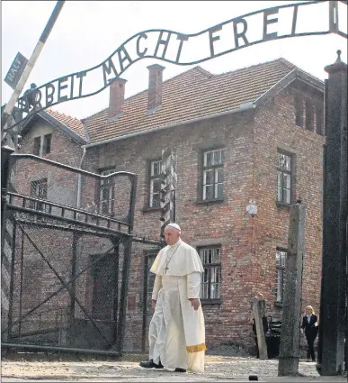  ?? Picture: KACPER PEMPEL / REUTERS, EPA ?? The Pope walks alone through the gates of Auschwitz yesterday, below its notorious iron sign