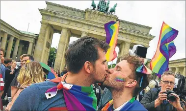  ?? AFP ?? CELEBRACIO­N. Una pareja gay festeja la aprobación de la ley en la famosa Puerta de Brandeburg­o.