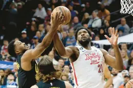  ?? ELIZABETH ROBERTSON/THE PHILADELPH­IA INQUIRER ?? The 76ers center Joel Embiid gets fouled by the Utah Jazz’s Malik Beasley on Sunday at the Wells Fargo Center in Philadelph­ia.