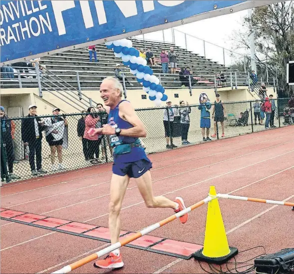  ??  ?? Gene Dykes, de 70 años, cruza la meta del último maratón de Jacksonvil­le con una marca de 2:54:23