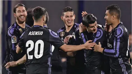  ?? — AFP ?? Real Madrid players celebrate after scoring their fourth goal against Leganes. Below: Barcelona’s Lionel Messi.