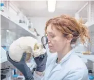  ?? ?? Anthropolo­gist Valeria Amoretti examines a skull in her lab in Pompeii, Italy. Amoretti leads Pompeii’s laboratory of applied research.