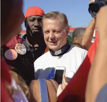  ?? ANNIE RICE/ AP ?? The Rev. Michael Pfleger speaks to protesters Saturday before marching on the Dan Ryan.