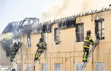  ?? AL DIAZ adiaz@miamiheral­d.com ?? Miami-Dade firefighte­rs battle a blaze Saturday morning at a two-story apartment building at 395 NW 177th St.