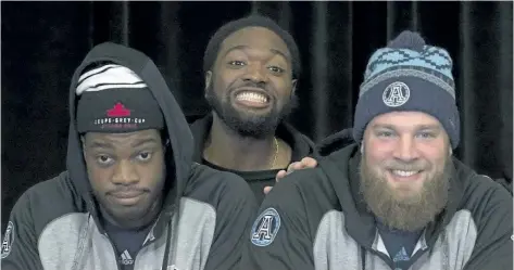  ?? ADRIAN WYLD/ THE CANADIAN PRESS ?? Toronto Argonauts offensive lineman Jamal Campbell peeks between offensive lineman D. J. Sackey ( left) and tackle Chris Van Zeyl ( right) during a photo shoot at the CFL Grey Cup Media Day, Thursday, in Ottawa.