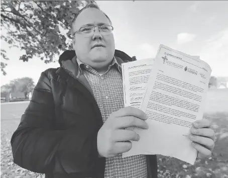  ?? DAN JANISSE ?? Eric Renaud, a recent candidate for a trustee seat on the Windsor-Essex Catholic District School Board, holds a copy of a letter signed by Catholic educators urging Catholic voters not to support candidates advocating amalgamati­on of school board administra­tions.