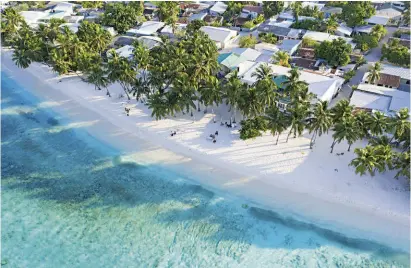  ??  ?? Maalhos, splendida isola abitata nell'atollo di Baa, fra i tetti del villaggio ospita varie guesthouse, caffè e compagnie locali di escursioni marine. A destra, una tipica strada di sabbia battuta che porta al mare nel villaggio di Fulidhoo, sull'atollo di Vaavu. Molte case locali maldiviane sono ancora fatte di corallo.