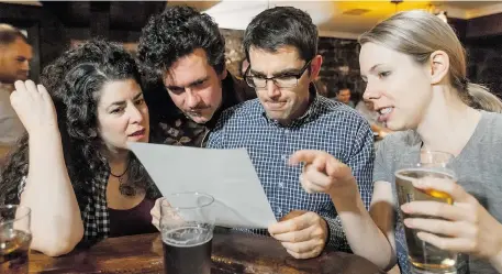  ?? DAVE SIDAWAY/ THE GAZETTE ?? From left, Molly Ann Rothschild, André Kirchhoff, William Dolan and Monique Muise look over their answers during Quiz Night at Grumpy’s.