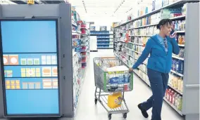  ??  ?? A customer pulls her shopping cart past an informatio­n kiosk at a Walmart Neighborho­od Market, Wednesday, April 24, 2019, in Levittown, New York. Kiosks and signs throughout the store keep customers informed that they are shopping in an artificial intelligen­ce factory.