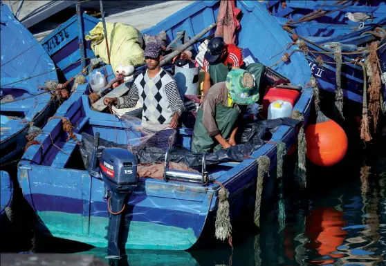  ??  ?? Photo ci-dessus : Des pêcheurs dans le port marocain d’Essaouira, sur la côte Atlantique. Connu pour ses ressources halieutiqu­es, le pays est notamment le premier producteur-exportateu­r mondial de sardines, une activité que le Royaume mène y compris dans les eaux adjacentes au Sahara occidental sous gestion marocaine. (© Shuttersto­ck/FuGazi images)