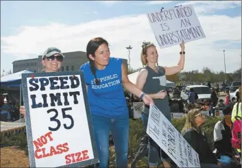  ?? AP photo ?? Oolagah, Okla., teachers (from left) Melinda Dale, Scarlett Sellmeyer and Sierra Ryan, hold signs at the state Capitol in Oklahoma City on Tuesday as protests continue over school funding. After a day of instructin­g 1st-graders at Oologah-Talala Public...