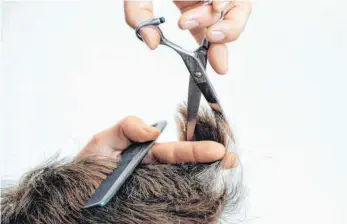  ?? FOTO: SUSANN PRAUTSCH/DPA ?? Ein Friseur schneidet die Haare und hat in Zeiten wie diesen deutliche Mehrkosten aufzuwende­n.