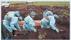  ??  ?? LETHAL VARIANT Funeral staff in protective gear in South Africa