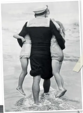  ??  ?? TOP A sailor is determined to take two little girls under his arms for a paddle. August 1946