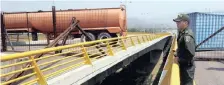  ??  ?? A Colombian police officer observes the blockade of the border bridge of Tienditas between Colombia and Venezuela, in Cucuta, Colombia, to prevent humanitari­an aid from being delivered to Venezuela. |