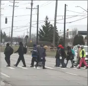  ??  ?? Employees at Warren’s Truck Assembly Plant walk across Mound Road to get to their vehicles.