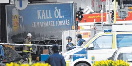  ?? FOTO: AFP ?? Polizisten sichern in Stockholm am Freitagnac­hmittag den Tatort und den verwendete­n Lastwagen.