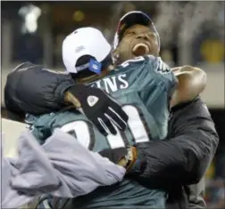  ?? MILES KENNEDY — THE ASSOCIATED PRESS ?? Eagles wide receiver Terrell Owens hugs teammate Brian Dawkins after the Eagles’ 27-10 victory over the Atlanta Falcons in the NFC championsh­ip game in 2005.