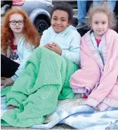 ??  ?? ■ ABOVE: Addisyn Reeves, left, Molly Pruitt and MaKenzy Reeves have found a cozy way to wait for a parade. They have blankets and friends around them.