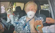  ?? (AP/Andre Penner) ?? Maria Helena Alcantara gets a shot of the Sinovac vaccine while she sits in her car with her pets during a priority vaccinatio­n program for seniors at a drive-through site set up in the Pacaembu soccer stadium parking lot in Sao Paulo, Brazil.