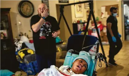  ?? Photos by Jon Shapley / Staff photograph­er ?? Hailey Cheevers, 10, rests as her father, Stan, left, and Samir Haq, a nurse, adjust the home after last week’s deep freeze.