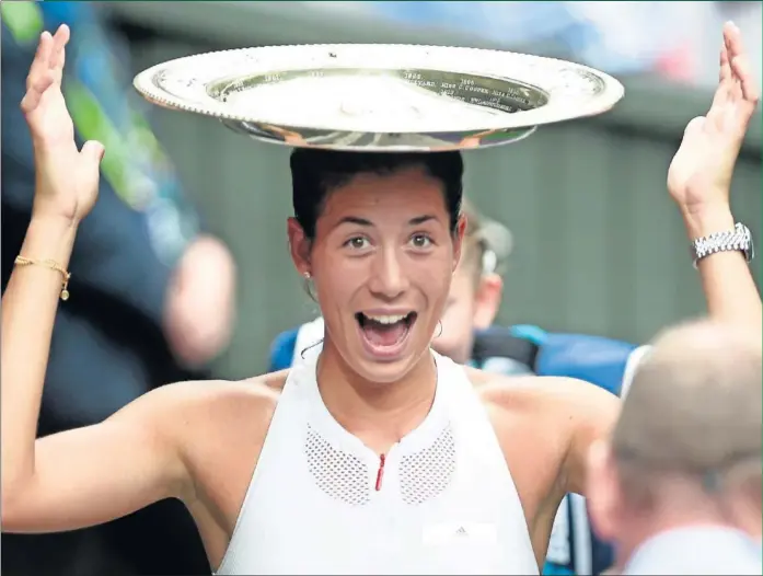  ??  ?? EN LA CUMBRE. Garbiñe Muguruza se coloca en la cabeza el Venus Rosewater Dish, trofeo que la acredita por primera vez como campeona de Wimbledon.