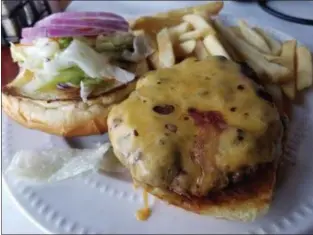  ?? MARK KOESTNER — THE NEWS-HERALD ?? The Roadhouse burger at the Original Roadhouse involves a half-pound of beef and a pretzel bun.