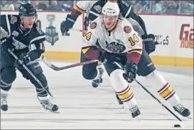  ??  ?? Wolves forward Tim Miller advances the puck during Game 3 against the San Antonio Rampage. | ROSS DETTMAN~CHICAGO WOLVES