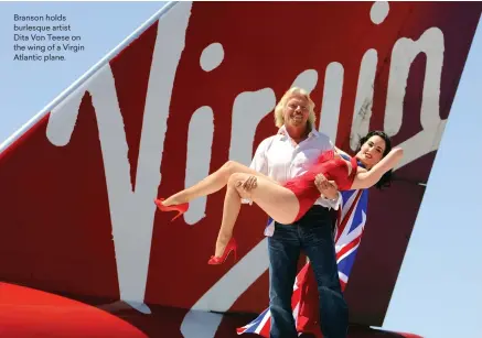  ??  ?? Branson holds burlesque artist Dita Von Teese on the wing of a Virgin Atlantic plane.