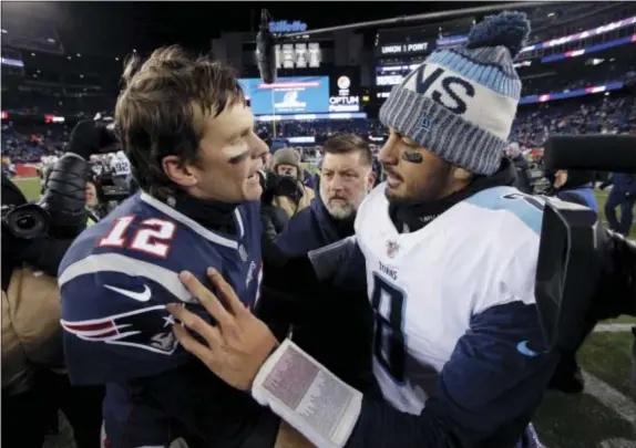  ?? STEVEN SENNE — THE ASSOCIATED PRESS ?? New England Patriots quarterbac­k Tom Brady, left, and Tennessee Titans quarterbac­k Marcus Mariota speak at midfield after an NFL divisional playoff football game, Saturday in Foxborough, Mass.