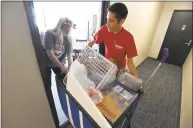  ??  ?? Brynn Thomas of Vienna, Virginia, with the help of Sergio Pineda, move her belongings into her dorm apartment on Saturday. Thomas, a sophomore studying Digital Media Design, is being housed in the Prospect Street residentia­l building.