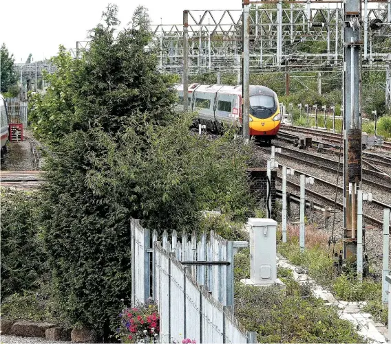  ?? MRS J A CLOUGH. ?? Tilting trains eventually ran in commercial service on the West Coast Main Line in the form of Class 390 Pendolinos and Class 221 Super Voyagers. The last surviving APT prototype train sits forlornly in a siding at Crewe Heritage Centre on August 8 2015, while a Pendolino rushes past forming the 1251 Edinburgh to Euston.