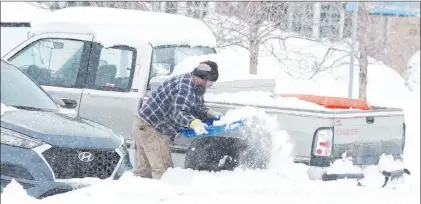  ?? Michael Cummo The Associated Press ?? A man uses a plastic sled to shovel out his truck out of the snow Monday in Cheyenne, Wyo.