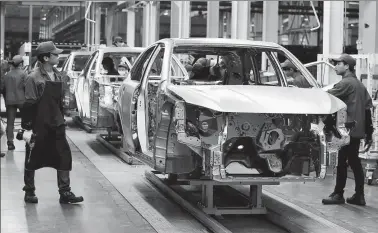  ?? REUTERS ?? Employees work on a BYD assembly line in Shenzhen, Guangdong province.