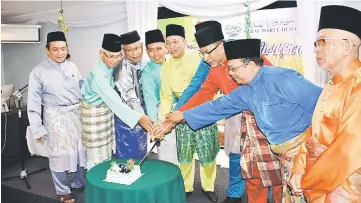  ??  ?? Fadillah (centre) leads the cake-cutting ceremony at the dinner event in Kuching.