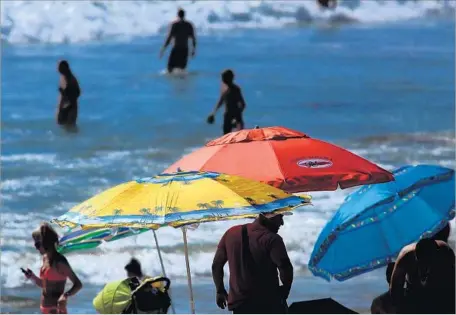  ?? Genaro Molina Los Angeles Times ?? SOME BEACHGOERS cool off under umbrellas while others choose to chill out in the water on the north side of the Santa Monica Pier.