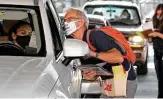  ?? Tom Reel / Staff photograph­er ?? Ralph Domas helps a driver in a voter registrati­on event in a parking lot under U.S. 281 on Tuesday.