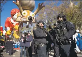  ?? CRAIG RUTTLE — THE ASSOCIATED PRESS ?? Heavily armed members of the New York Police Department take a position along the route Thursday before the start of the Macy’s Thanksgivi­ng Day Parade in New York.