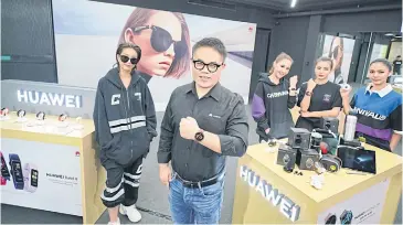  ??  ?? Mr Wang stands alongside presenters promoting gadgets at Huawei’s launch event.