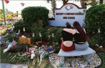  ?? Matias J. Ocner / Miami Herald 2020 ?? Mourners visit a memorial outside Marjory Stoneman Douglas High School in Parkland, Fla., on Feb. 14, 2020 — the second anniversar­y of the mass shooting that killed 17 people.