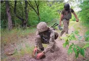  ?? EFREM LUKATSKY/ASSOCIATED PRESS ?? Soldiers of Ukraine’s special operations unit lay antitank mines on a forest road potenitall­y in Russian troops’ way in the Donestsk region of Ukraine late Tuesday.