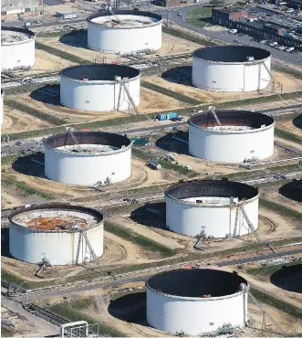  ?? SIMON DAWSON/BLOOMBERG FILES ?? Oil storage tanks sit at the Esso oil refinery in Fawley, U.K. The total proved reserves declined for the second consecutiv­e year for 68 oil companies listed on U.S. stock exchanges amid weak commodity prices shifting capital investment away from...