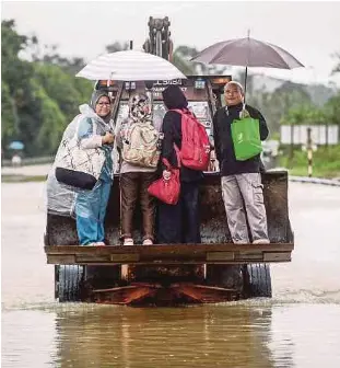  ?? ?? Penduduk menaiki jentera jengkaut di Jalan Kuala Berang, Hulu Terengganu.