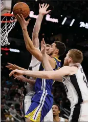  ?? SOOBUM IM — USA TODAY SPORTS ?? Klay Thompson shoots the ball between San Antonio’s Jakob Poeltl, behind, and Davis Bertans. Thompson had a rough night, missing 13of his 18attempts from the field.