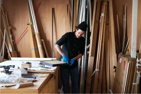  ??  ?? ABOVE
Tom in his studio making finishing touches by waxing a timber frame. OPPOSITE “Works often take months or years to resolve, so I hang them on the wall to contemplat­e,” says Tom. “Most ideas are discarded, but it’s the moment that a work or object has the energy to levitate that keeps me coming back for more.” He says when he hits a creative block, “removing myself mentally or physically is the only way I can overcome it. Heading somewhere remote without my phone helps, as does reading or listening to podcasts.”